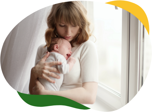 Mladá matka k sobě tiskne plačící miminko trpící dětskou kolikou ve snaze jej utišit.